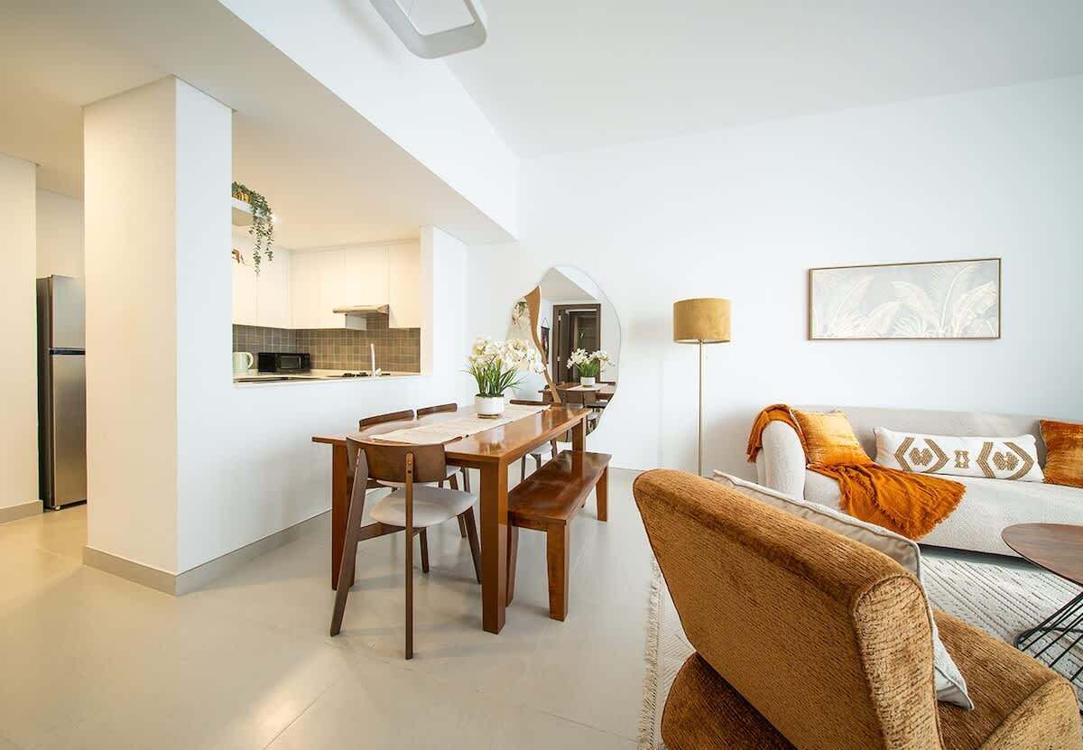 A modern living space with a dining area, kitchen, and seating area.