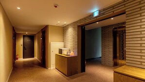 A hotel corridor with a reception desk, a "STAFF ONLY" door, and a fire extinguisher. - AVENUE S HOTEL (Siheung)
