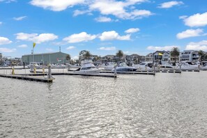 A marina with boats docked, a building in the background, and a clear sky.