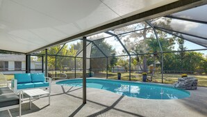 Ein Poolbereich im Innenbereich mit Überdachung, Liegestuhl und kleinem Tisch.