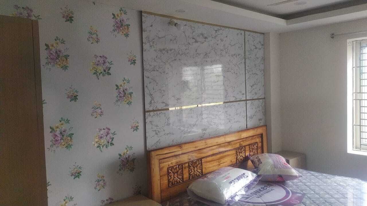 A bedroom with a bed, floral wallpaper, a wooden headboard, and a window with bars.