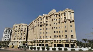 Un hotel de varios pisos con fachada simétrica, varios balcones y techo plano.