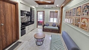 Una cocina moderna con zona de comedor, ventilador de techo y sofá.