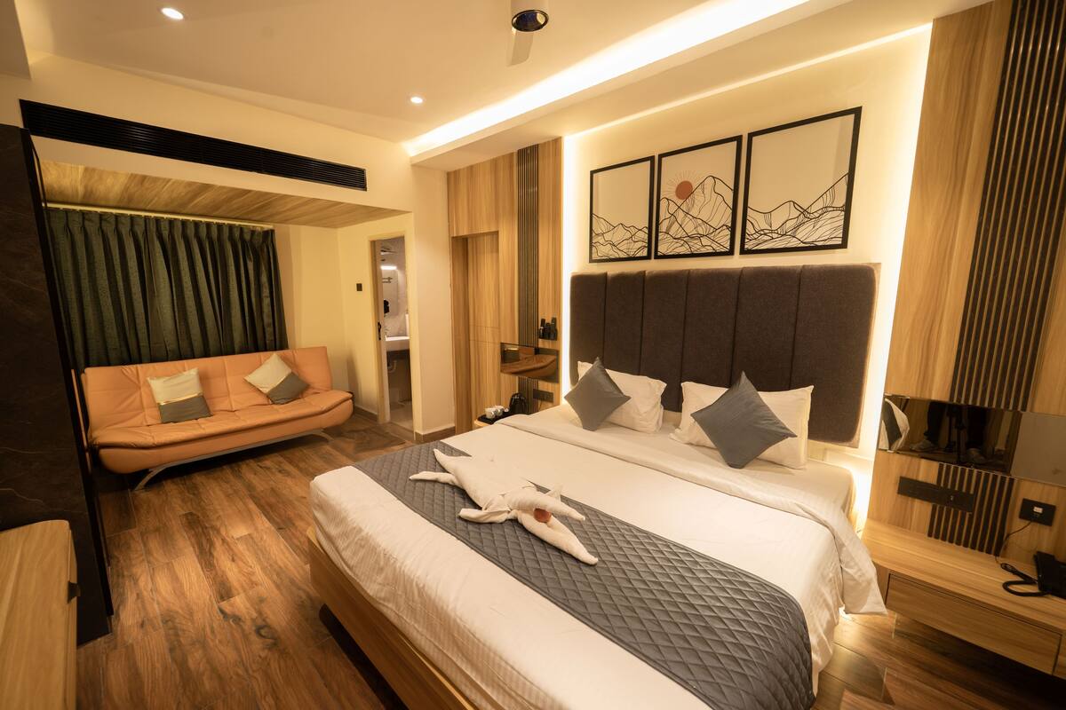 Een moderne hotelkamer met een groot bed, een bank en een bureau.