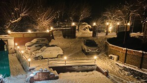 A snowy parking lot with cars and a building in the background. - The Gulmarg Palace (Gulmarg)