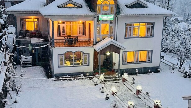 A multi-story building with a snow-covered roof and a sign reading 'Gulmarg Palace.' - The Gulmarg Palace (Gulmarg)