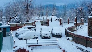 A snow-covered parking area with cars and a brick wall. - The Gulmarg Palace (Gulmarg)