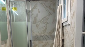 A bathroom with a glass shower enclosure, a sink, and a towel rack. - Cosy Paris apartment 5 minutes from Bastille! Ideal for sightseeing! (Paris)