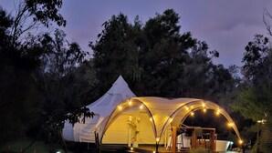 A large, dome-shaped tent with a flat roof, surrounded by a grassy area with a small wooden table and benches. - Lakebrook Country Escape (Carlotta)