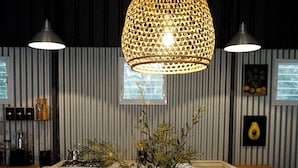 A modern kitchen with a central island, two pendant lights, and a hanging light fixture. - Lakebrook Country Escape (Carlotta)