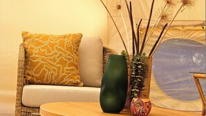 A cozy living area with a sofa, a coffee table, and decorative items including a vase and dandelion seed heads. - Lakebrook Country Escape (Carlotta)