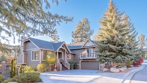 A two-story house with a stone foundation, a garage, and a driveway leading to the entrance. - New! Bearadise ~ The Retreat (Big Bear Lake)