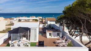 A rooftop terrace with a dining area, lounge chairs, and a view of the sea. - Misefo by Rentallorca (Son Serra de Marina)
