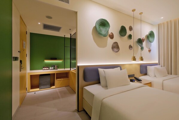 Une chambre d’hôtel moderne avec deux lits, un mur vert et des œuvres d’art décoratives.
