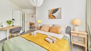 Een hotelkamer met een bed, nachtkastjes, een bureau en een stoel.