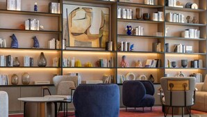 A modern living room with a bookshelf, seating, and a coffee table. - Wanda Moments Luoyang (Luoyang)