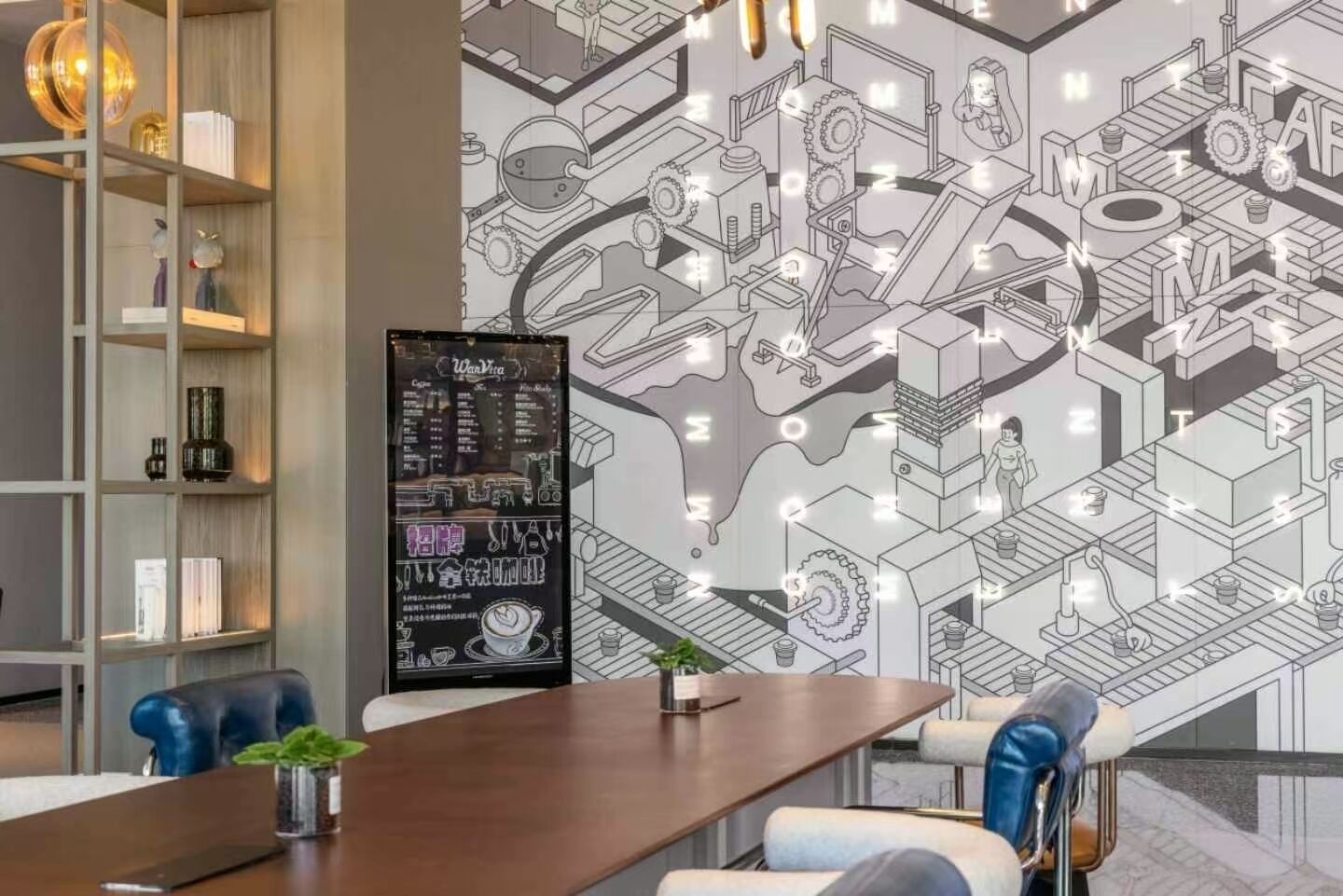 Une salle de réunion moderne équipée d’une longue table, de chaises bleues, d’une bibliothèque et d’un tableau noir servant de menu.