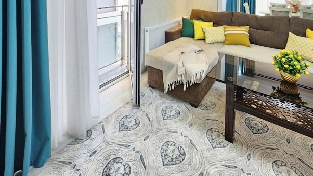 A modern living room with a glass coffee table, a sofa with yellow cushions, and a patterned rug. - Zarafshan city 64 Tashkent (Tashkent)