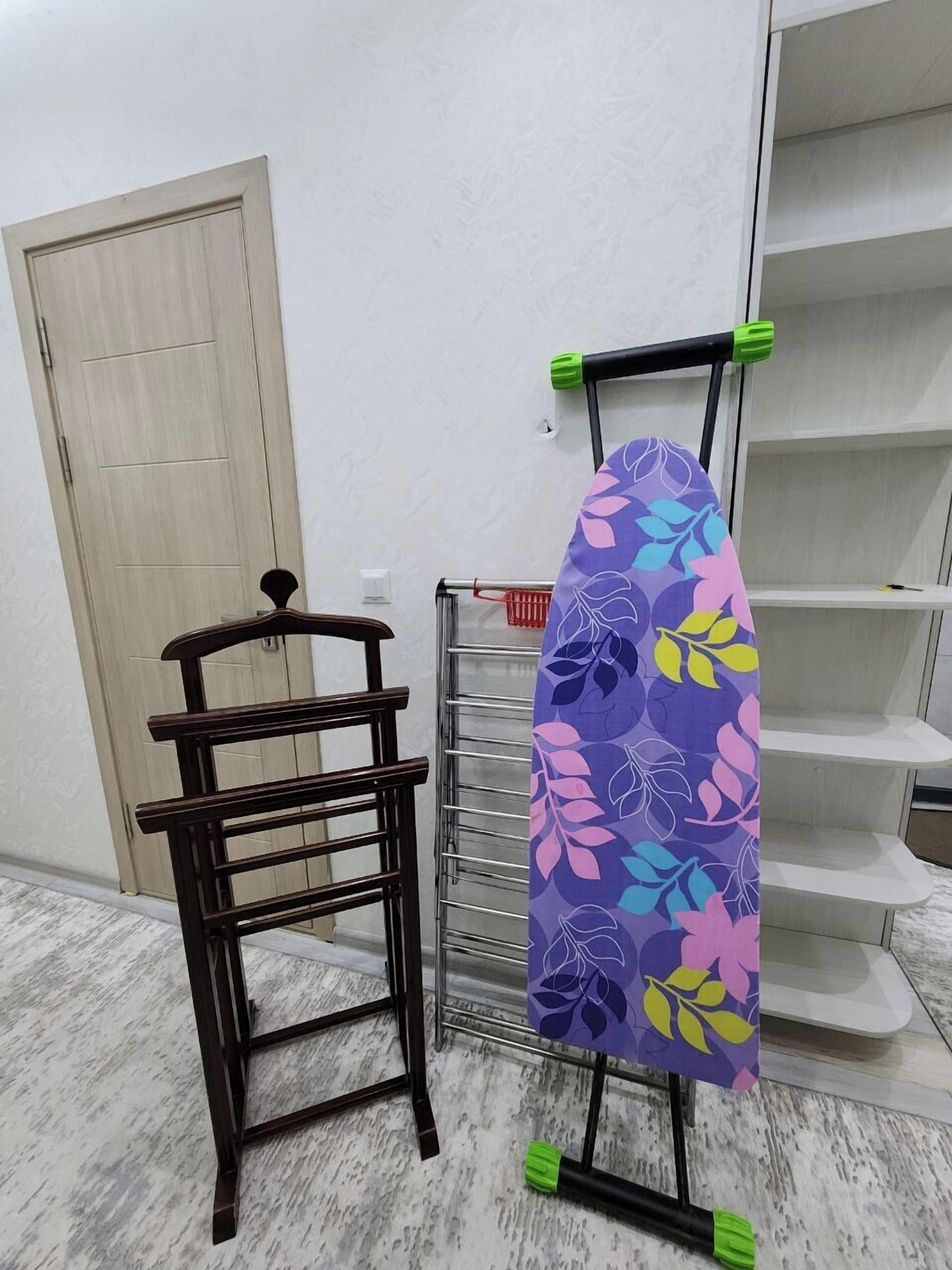 Ein Wäscheständer aus Holz mit einem Metallgestell und einem Surfbrett auf einem Ständer.