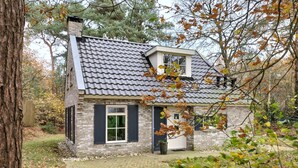 A two-story house with a tiled roof, brick walls, and a front door with shutters. - Cozy home in Lemele with heated swimming pool (Lemele)