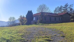 A house with a red roof, surrounded by trees and a grassy field. - Lovely home in Caranza(Varese Ligure) (Caranza(Varese Ligure))