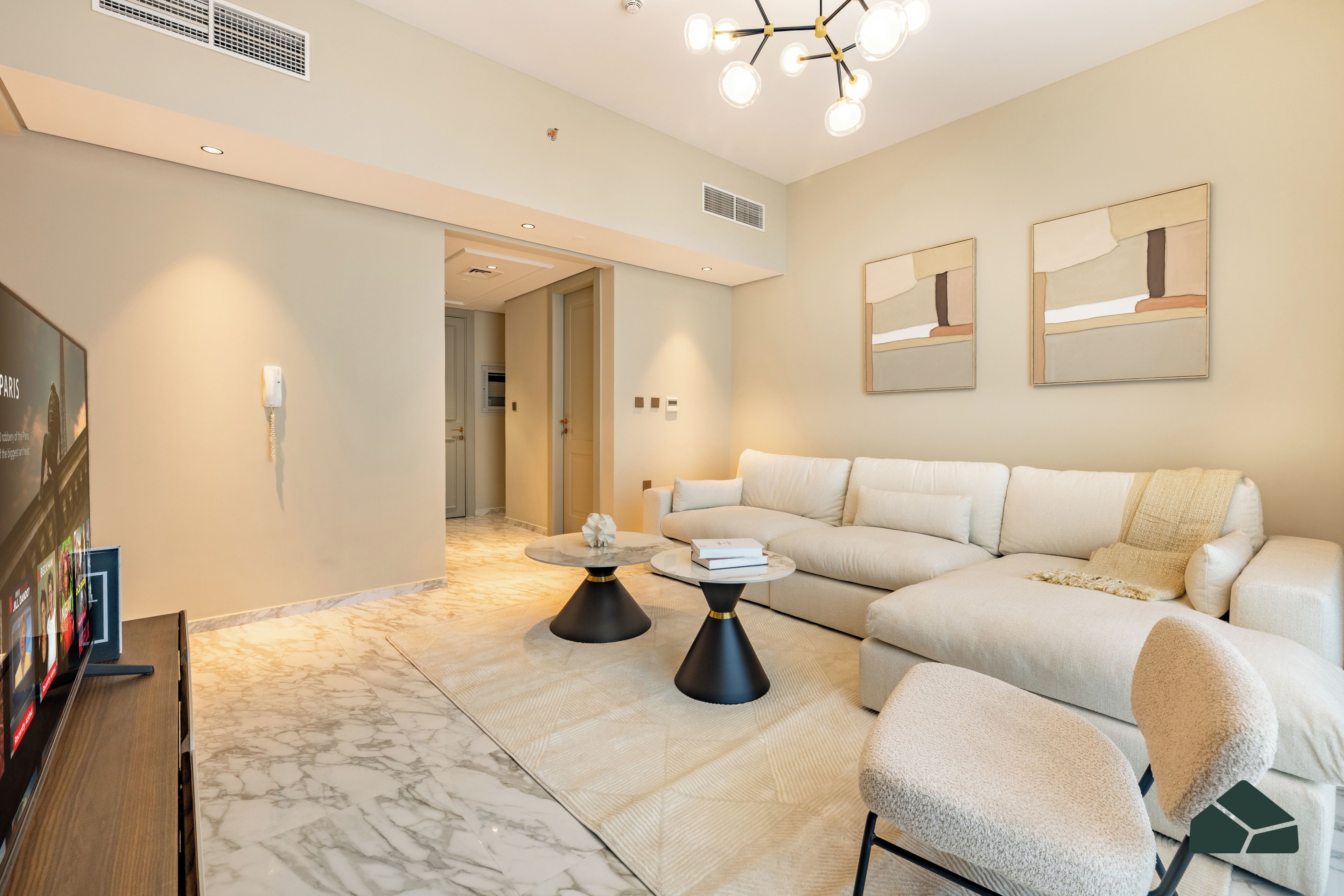 Una sala de estar moderna con un sofá modular, una mesa de centro y un televisor.