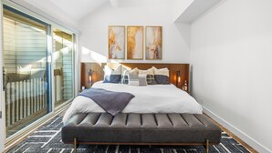 A modern bedroom with a large bed, a bench, and a sliding glass door leading to a balcony. - Park City Getaway with Mountain Views, Hot Tub & Fire pit | High West Hideaway (Park City)