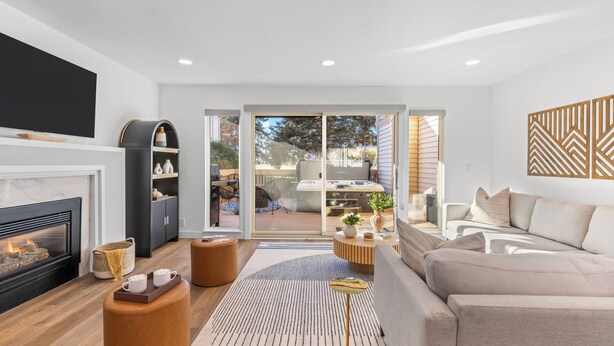 A modern living room with a fireplace, a sofa, a coffee table, and a TV. - Park City Getaway with Mountain Views, Hot Tub & Fire pit | High West Hideaway (Park City)