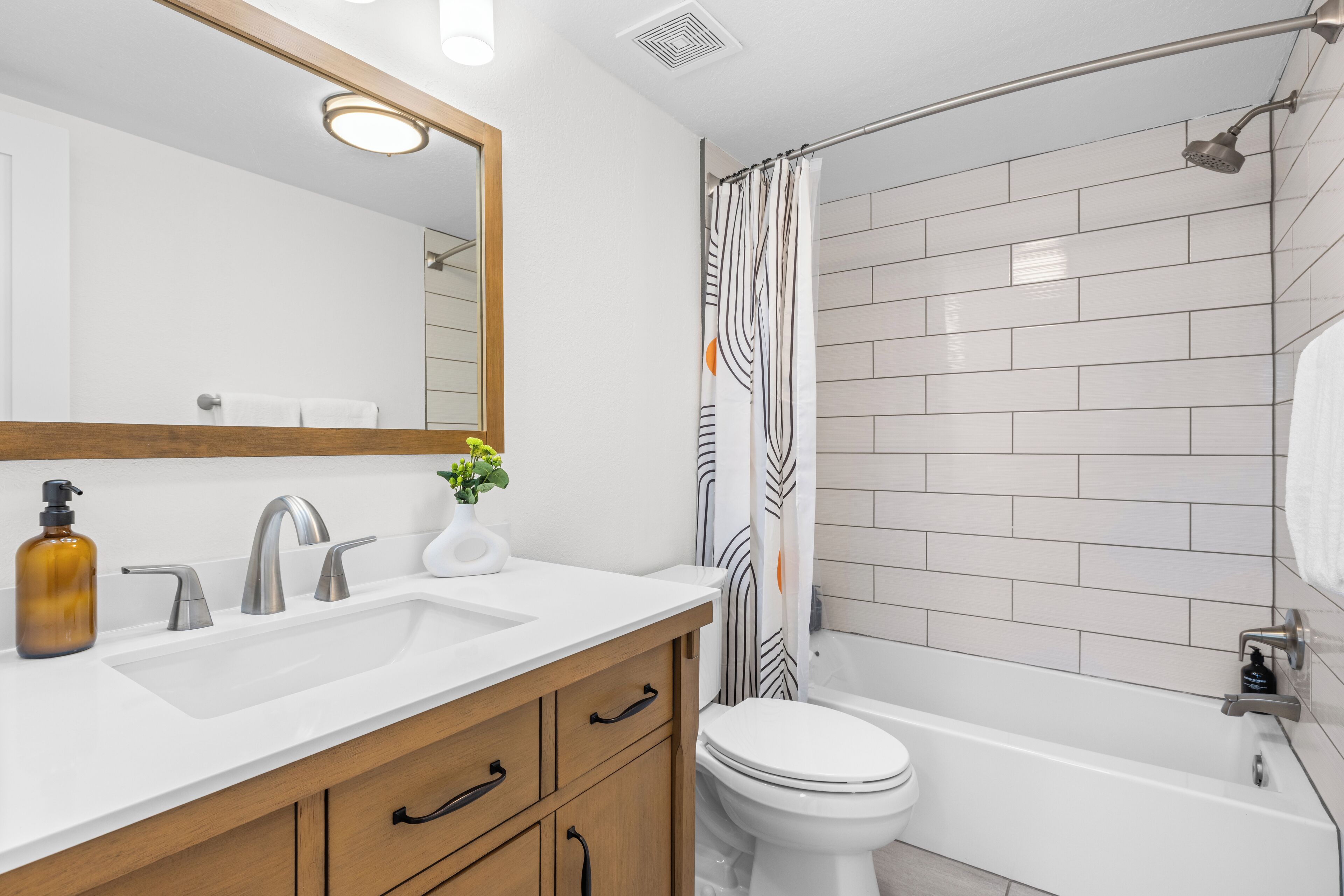 Un baño moderno con tocador doble, inodoro y bañera.