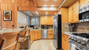 Una cucina moderna con mobili in legno, elettrodomestici in acciaio inossidabile e un piano di lavoro in granito.