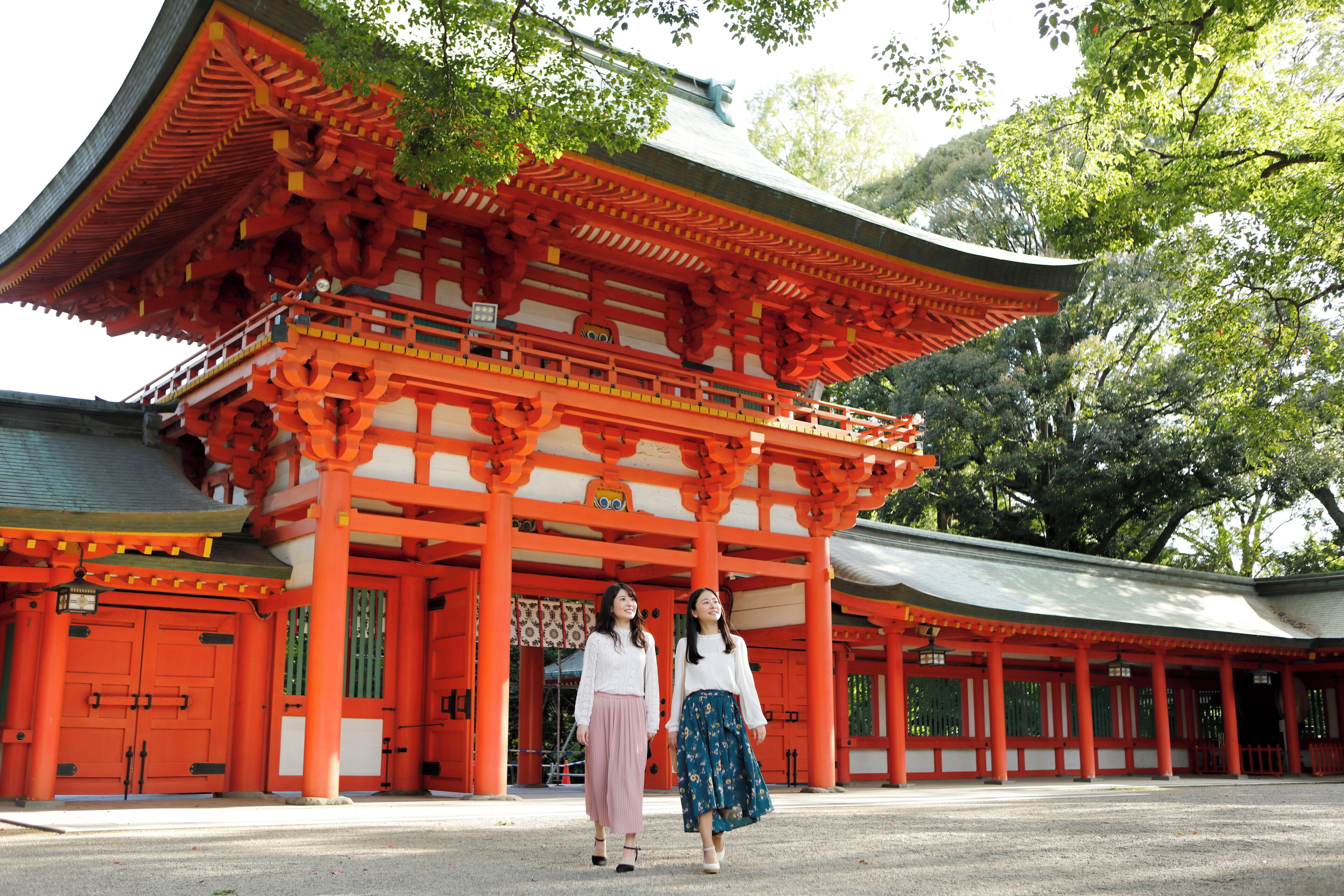 Un bâtiment traditionnel japonais, doté d’un portail torii rouge et d’une allée couverte.