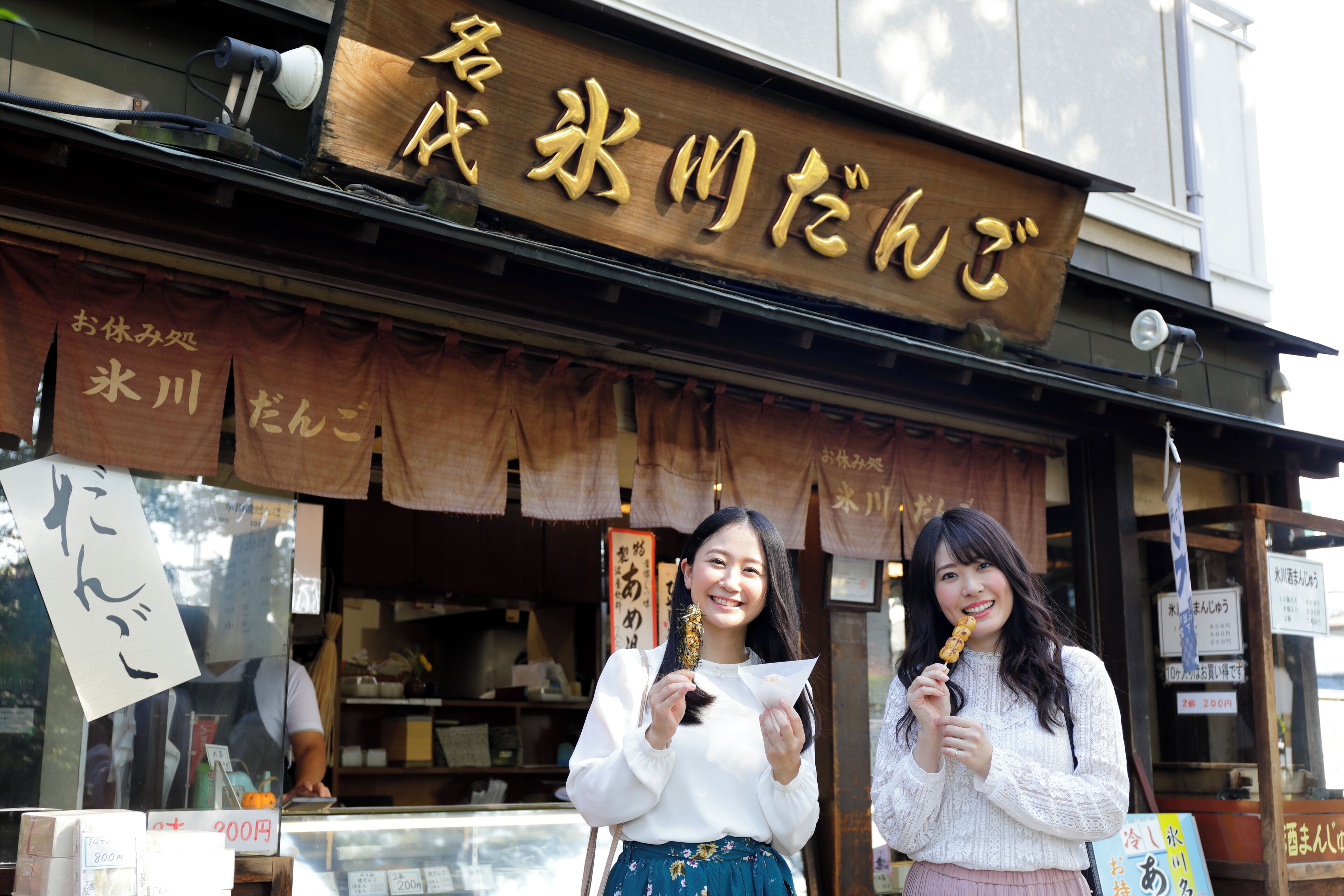 A storefront with a wooden sign and hanging banners.
