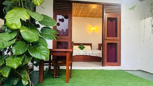 A room with a bed, a wooden chair, and a small table. - Ella Hide Forest Cottage (Ella)