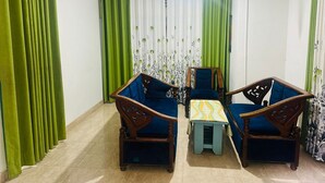 A room with two wooden chairs, a small table, and green curtains. - Ella Hide Forest Cottage (Ella)