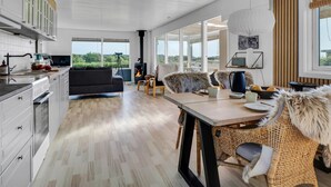 A modern kitchen with a dining area, large windows, and a view of the outdoors. - "Hjalma" - 250m to the fjord by Interhome (Farsø)
