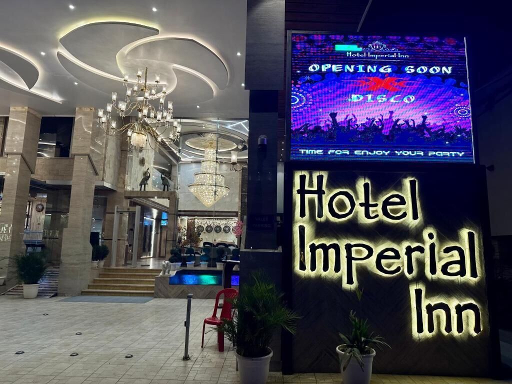 The entrance of Hotel Imperial Inn with a large illuminated sign announcing an upcoming disco event.