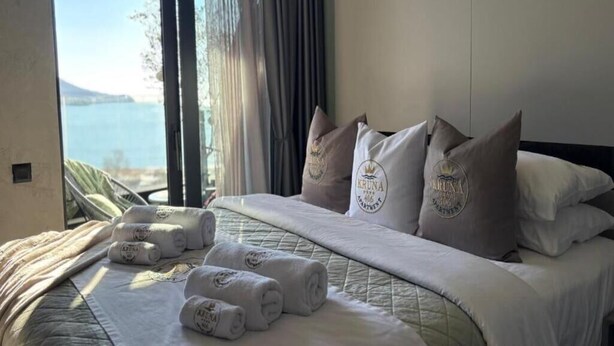 Een hotelkamer met een bed, kussens en handdoeken.