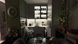 Een kleine keuken met een eethoek, een klok en een kerstboom.