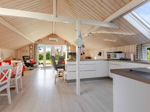 Ein großzügiges Loft mit hohen Decken, einer Küchenzeile und einem Essbereich.