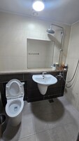 Un baño con inodoro, lavabo y ducha.
