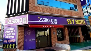 A multi-story building with a prominent 'Sky Motel' sign on the facade. - Sky Motel (Gumi)