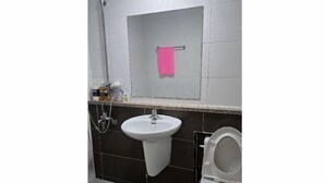 A bathroom with a white sink, a mirror, a pink towel, and a toilet. - Sky Motel (Gumi)