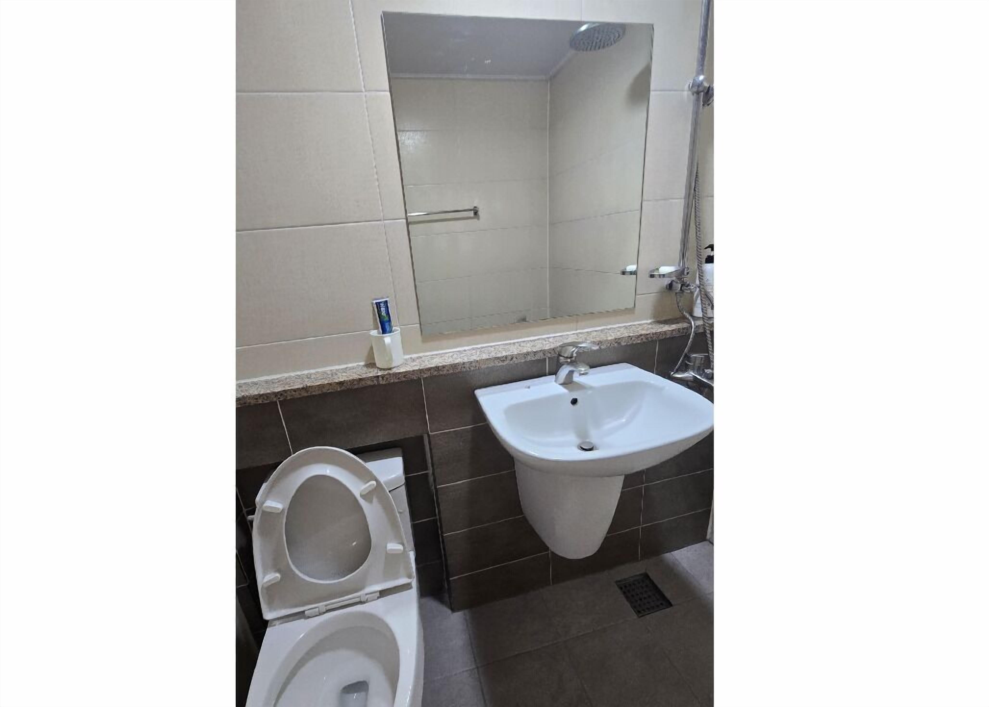 Une salle de bain avec des toilettes, un lavabo et une douche.