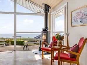 A room with a large window, a fireplace, and a view of the outdoors. - "Finn" - 100m from the sea by Interhome (Sydals)