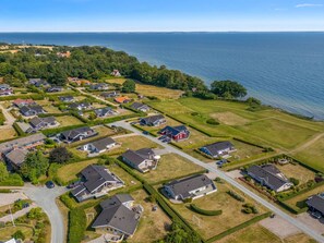 Un quartier résidentiel comprenant des maisons, des rues et une étendue d’eau.