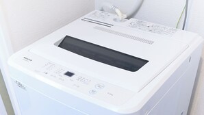 A white, compact, wall-mounted, multi-functional appliance with a control panel, a digital display, and a power cord. - Zenith Nishinakanobu (Tokyo)