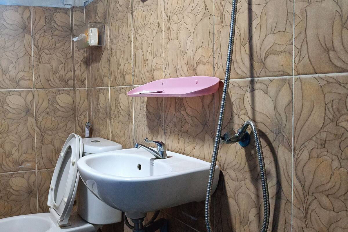 A bathroom with a toilet, sink, and shower.