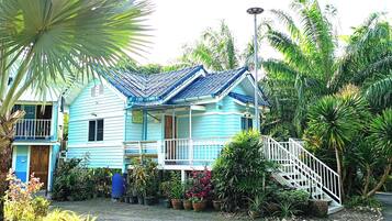 Una casa de dos pisos con fachada azul y balcón blanco.