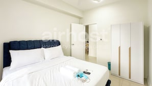 A hotel room with a bed, a wardrobe, a ceiling fan, and a bathroom visible through an open door. - Vista Sentul Residences by Airhost (Kuala Lumpur)