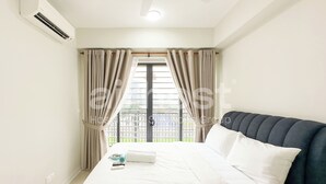 A hotel room with a bed, curtains, an air conditioning unit, and a view of a balcony. - Vista Sentul Residences by Airhost (Kuala Lumpur)